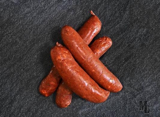 Salchicha/bratwurst ahumadas con chile y queso junto al fuego